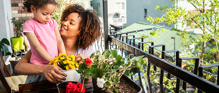 Woman and child planting flowers in outdoor garden